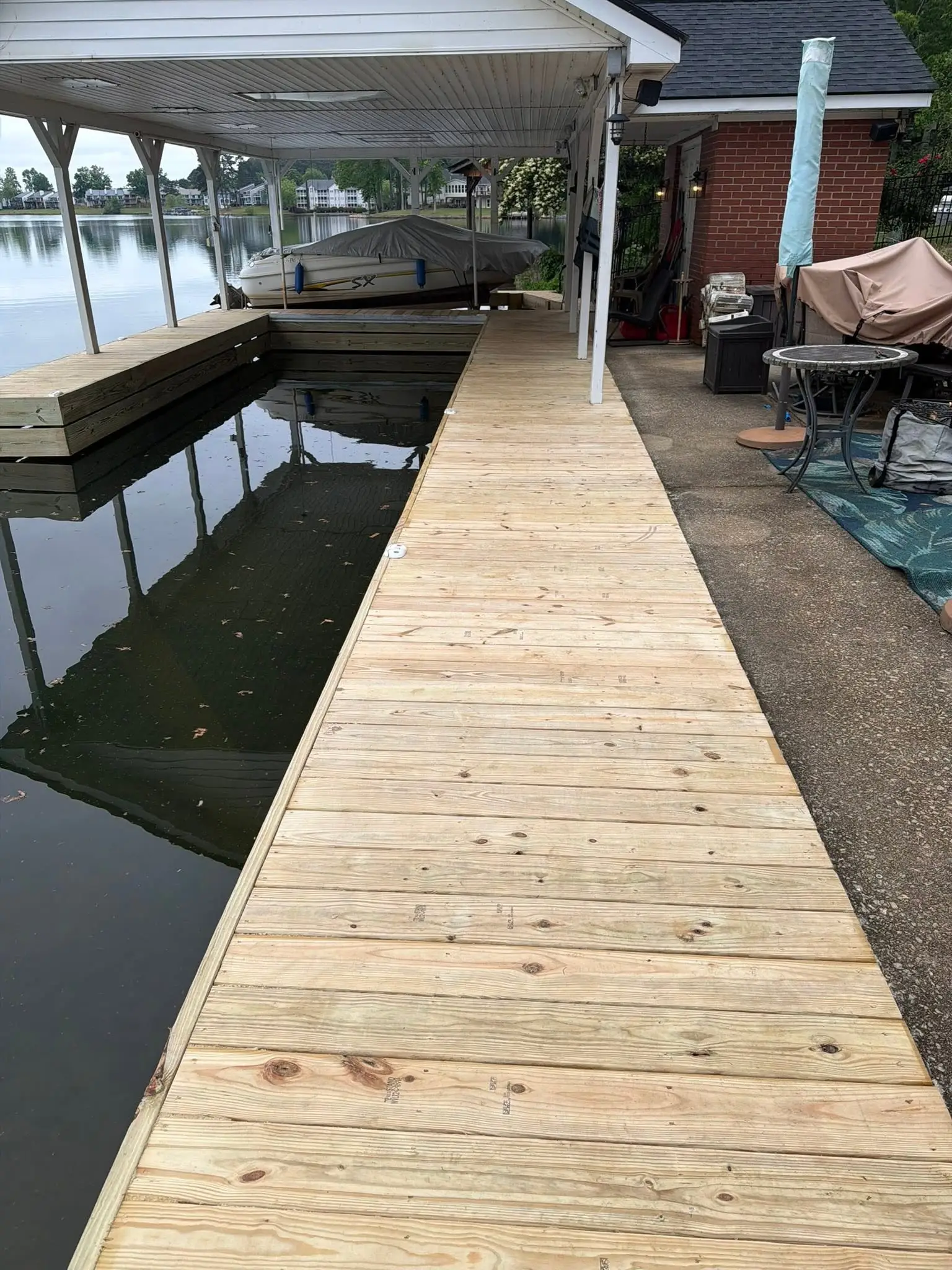 New decking and fascia board on a boardwalk out to a covered boathouse