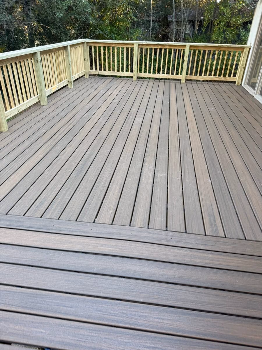 Rebuilt composite deck with new pressure-treated rails beside a sliding glass door
