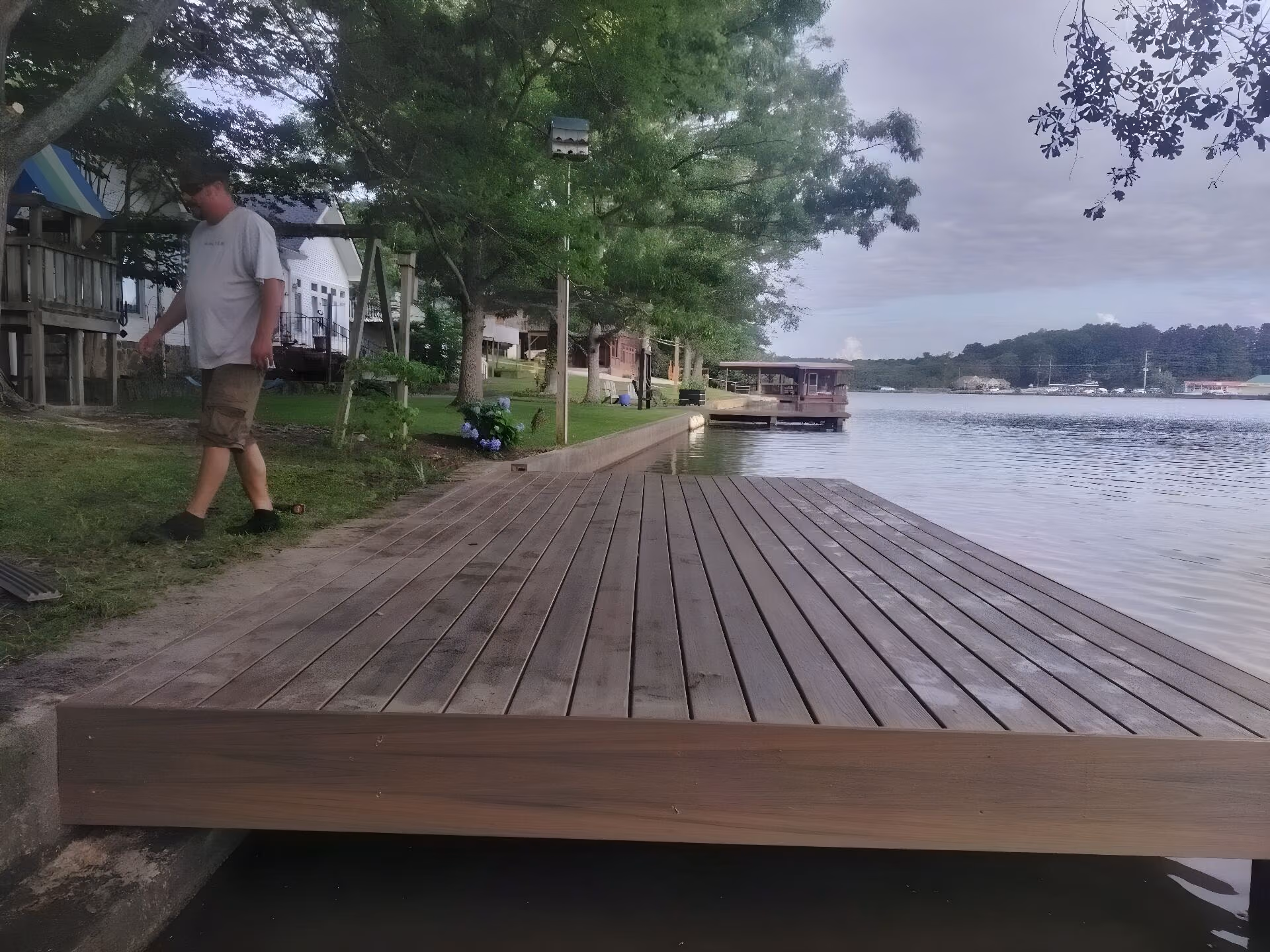 New composite dock platform at the water's edge, with a covered dock further down the same lake shore