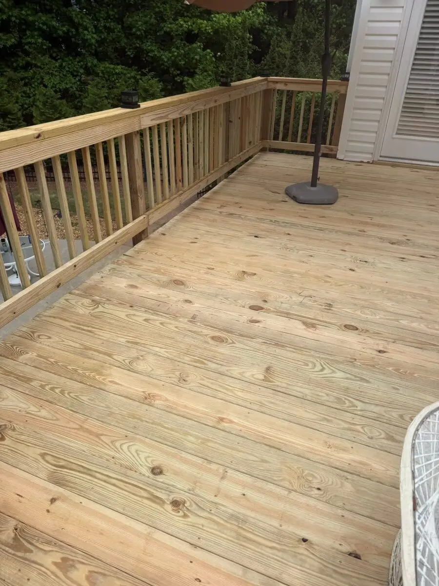 New pressure-treated deck with solar post caps and a patio umbrella