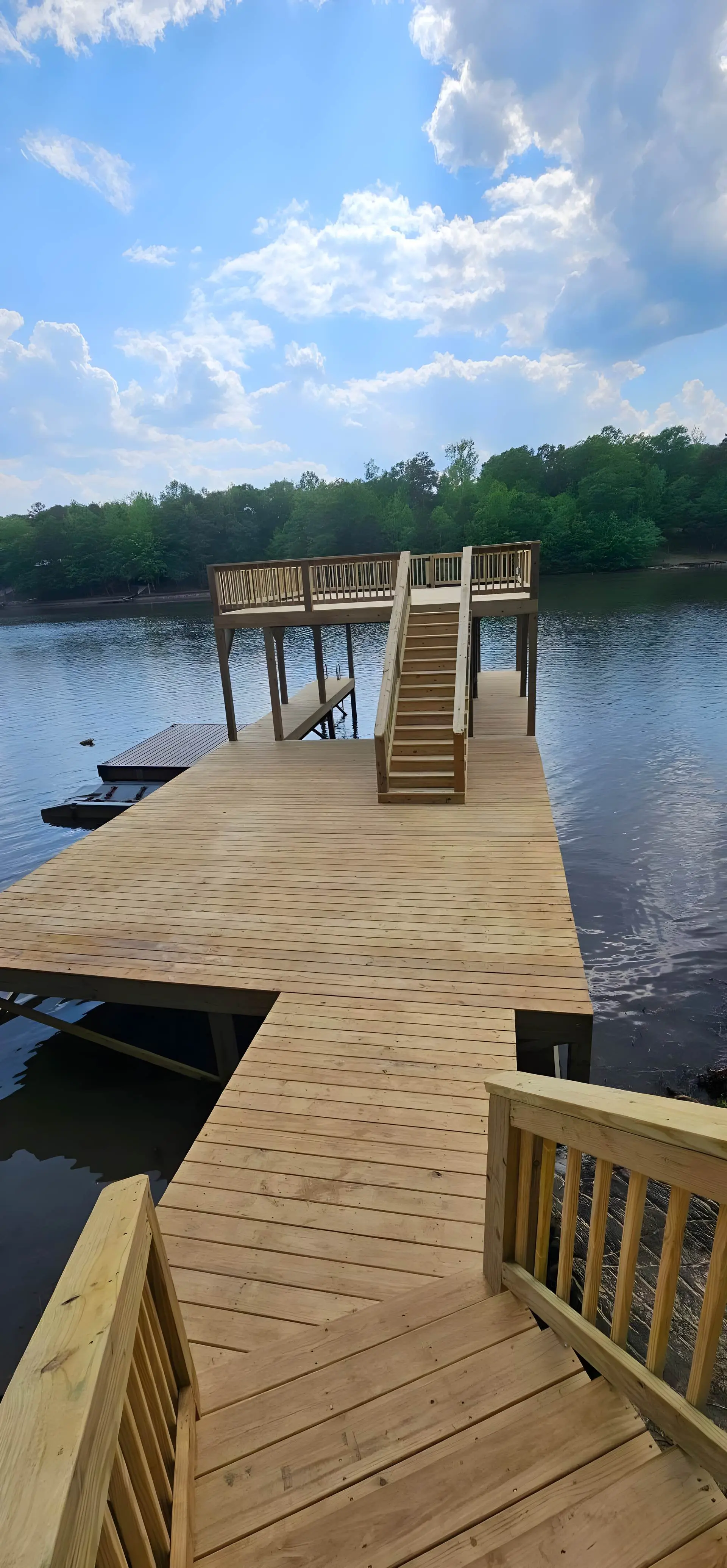 Pressure-treated dock with a walkway and upper platform on a west Georgia lake