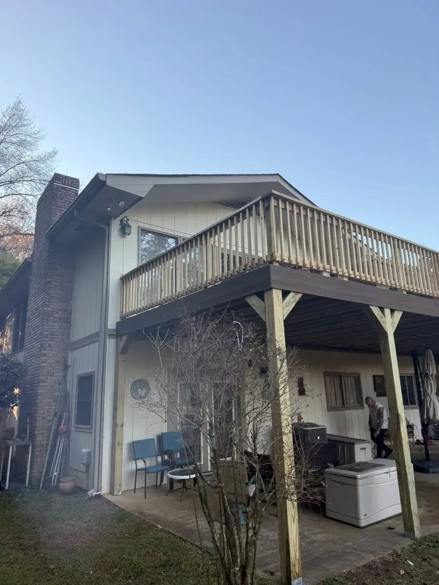 Large elevated deck rebuild with a covered patio below, crew on site
