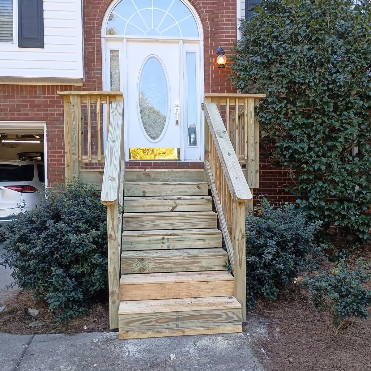 New pressure-treated deck stairs and railing at a brick home
