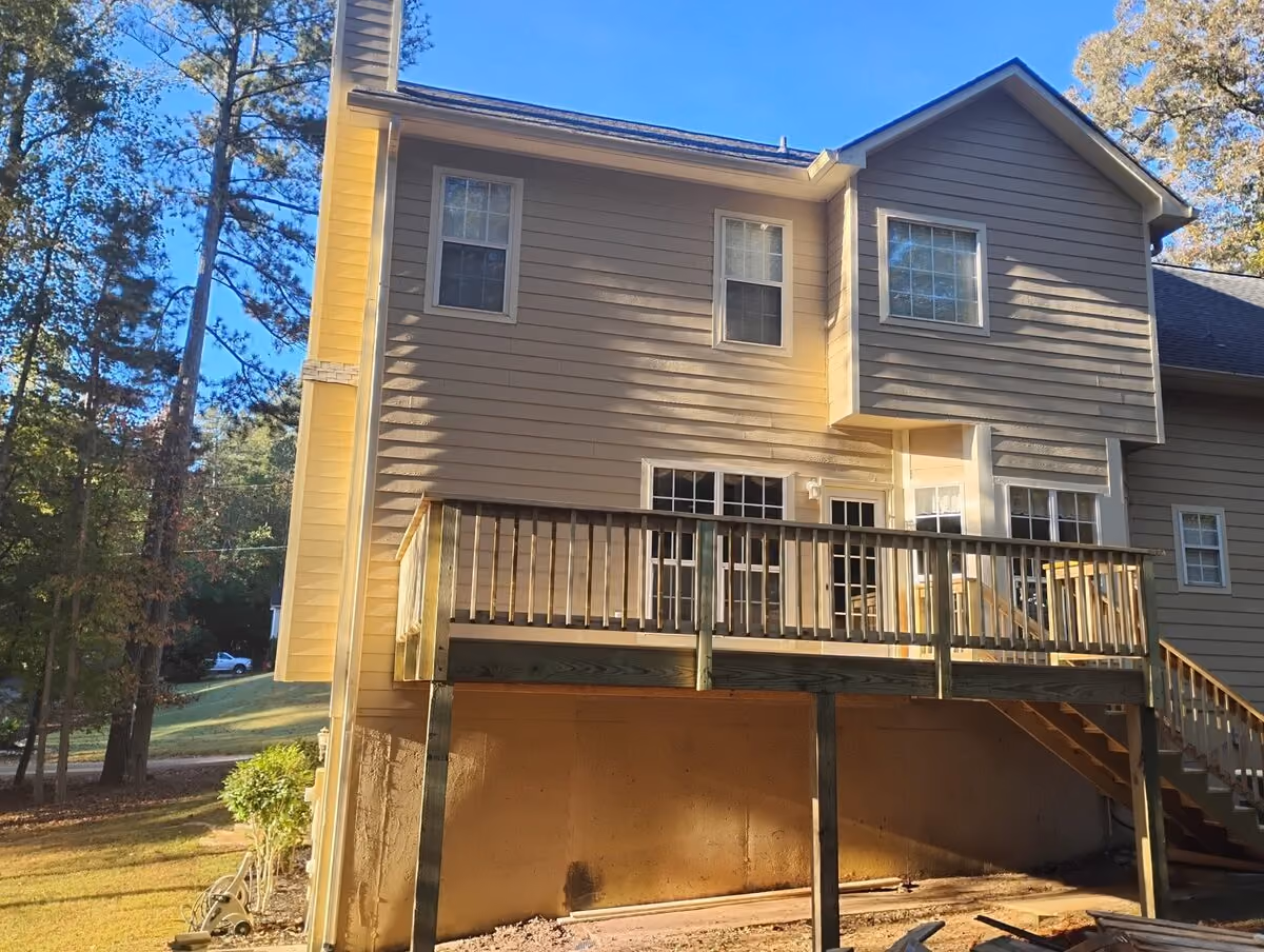 Brand-new pressure-treated deck and stairs on the back of a split-level home