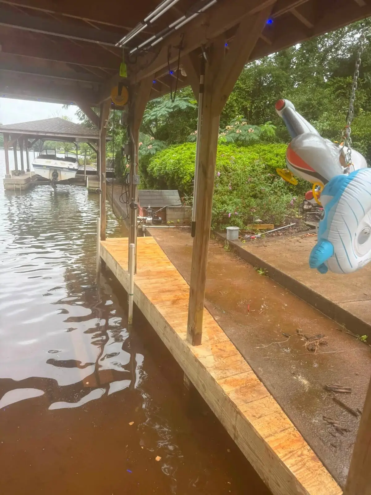 Freshly replaced dock decking beside a covered boathouse slip