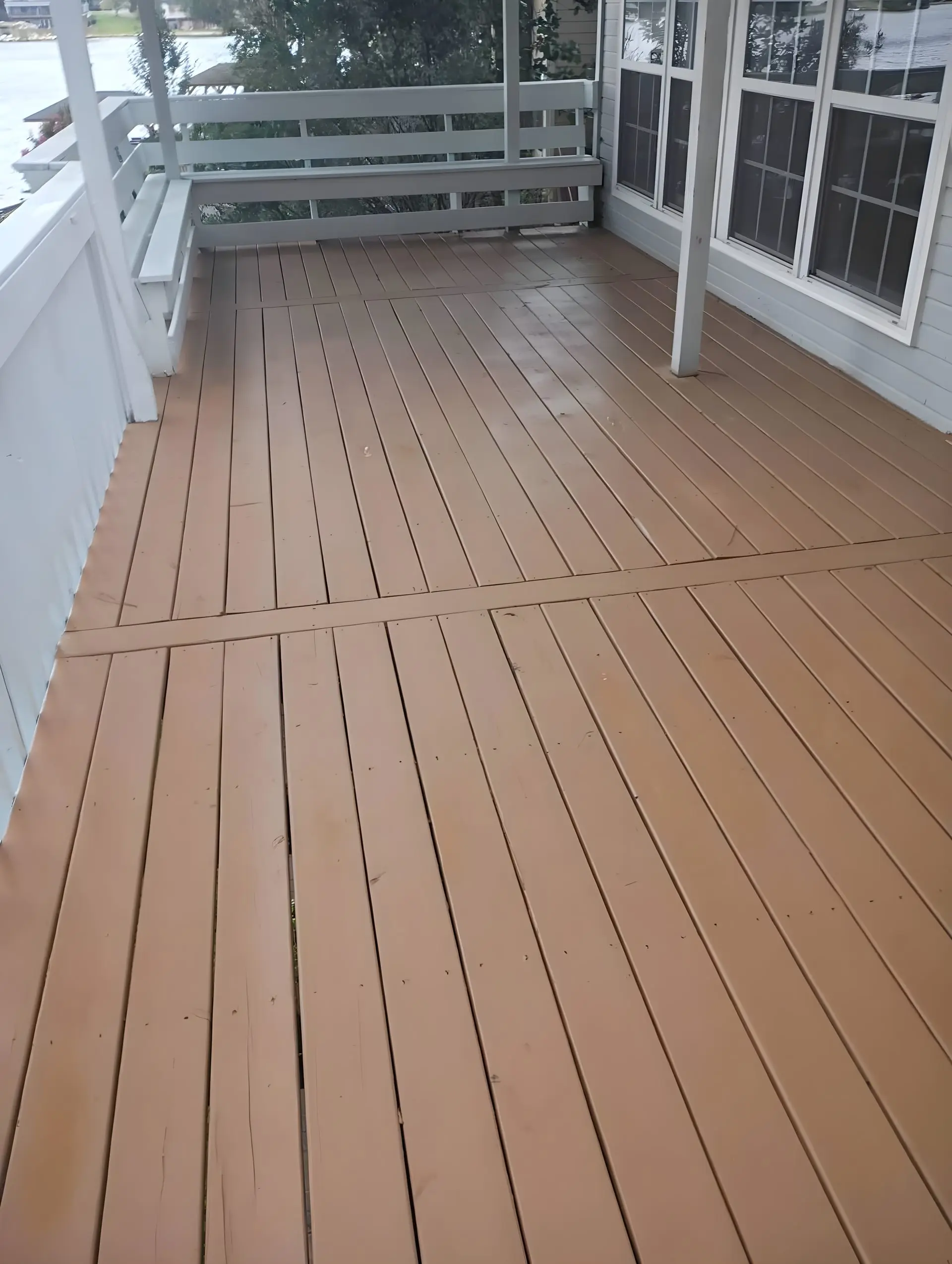 Finished stained deck with a white rail and an open lake view