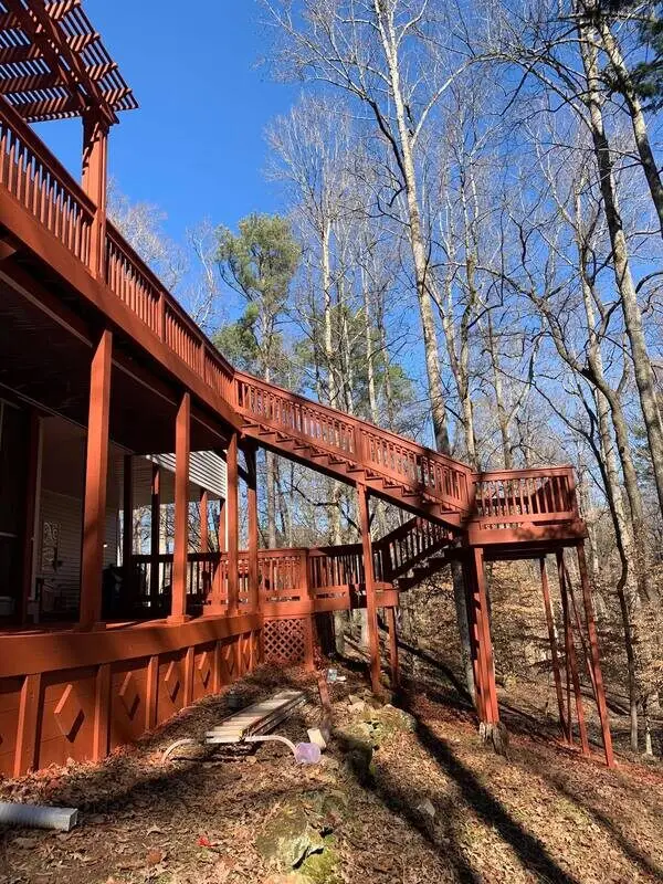 Long red-stained deck staircase descending through the trees
