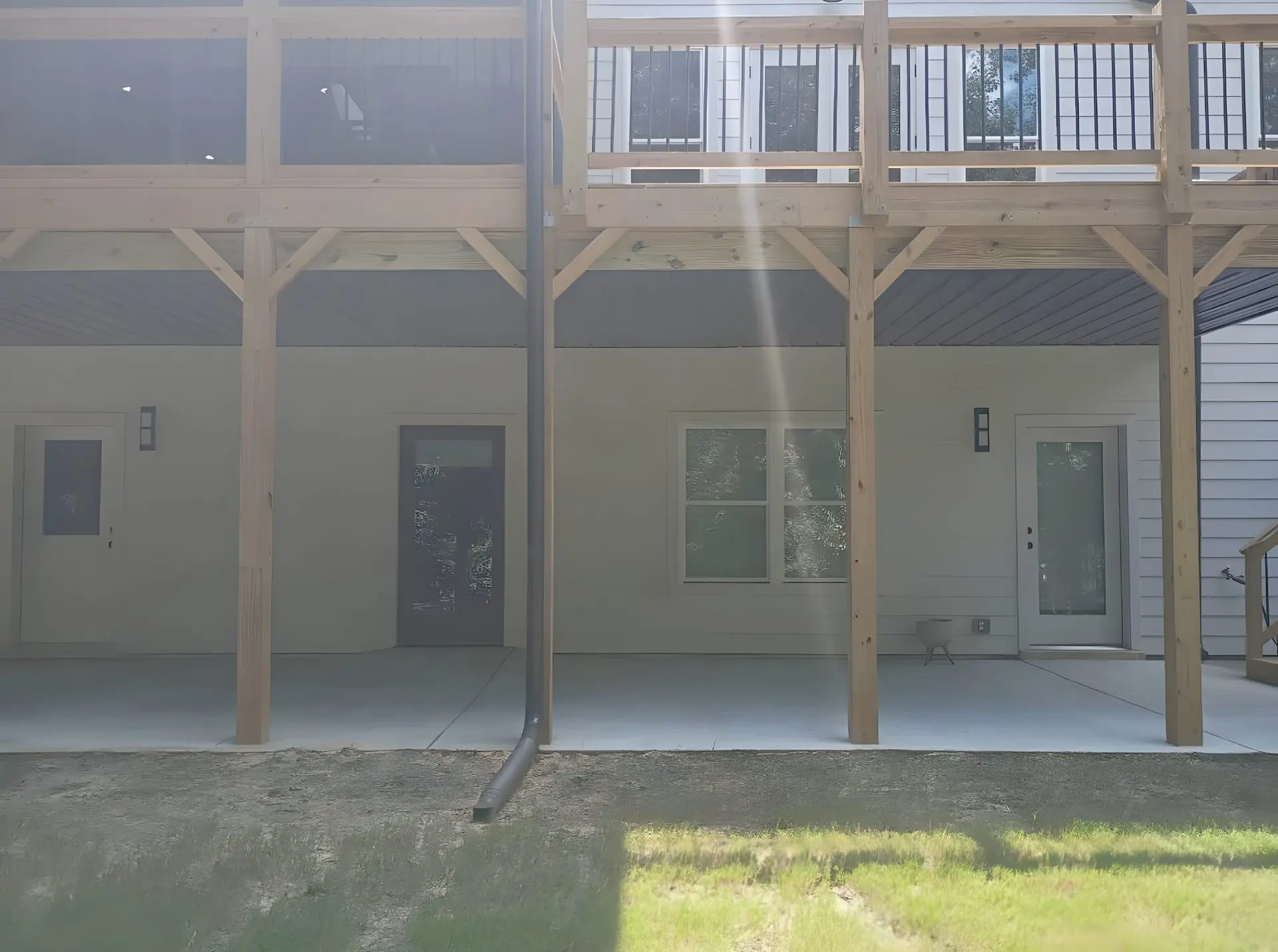 Two-story home addition with an elevated deck above and a finished covered patio below