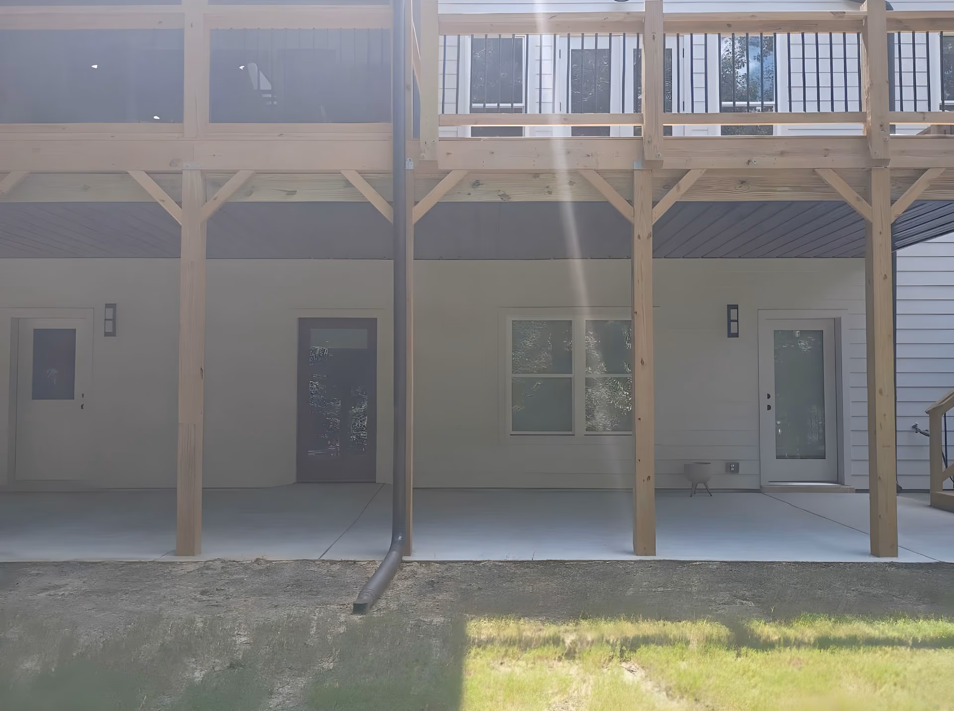 Two-story elevated deck over a finished covered patio with doors into the lower level of the house